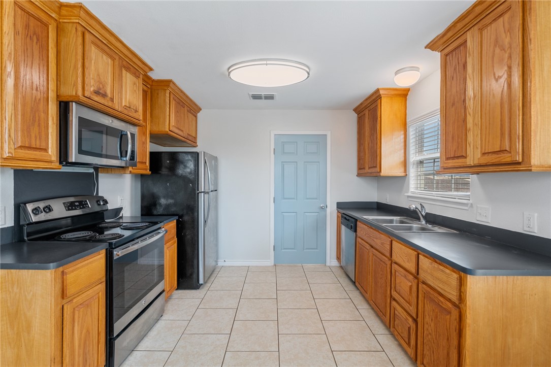 410 Knickerbocker Street Corpus Christi, TX 78418 - Photo 7 of 24 a kitchen with stainless steel appliances granite countertop a stove a sink and a microwave