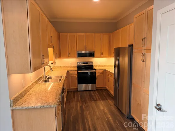 a kitchen with a refrigerator a stove top oven a sink and dishwasher