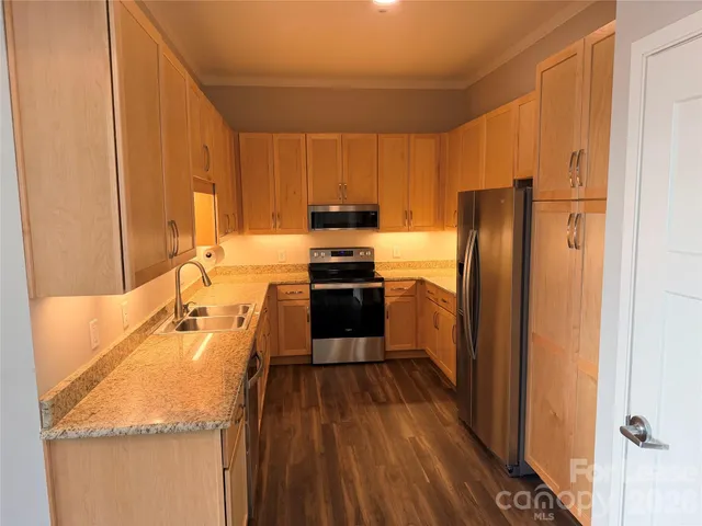 a kitchen with a refrigerator a stove top oven a sink and dishwasher