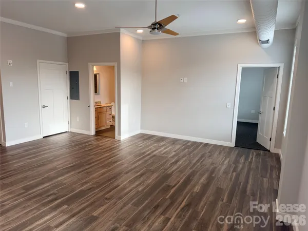 an empty room with wooden floor and ceiling fan