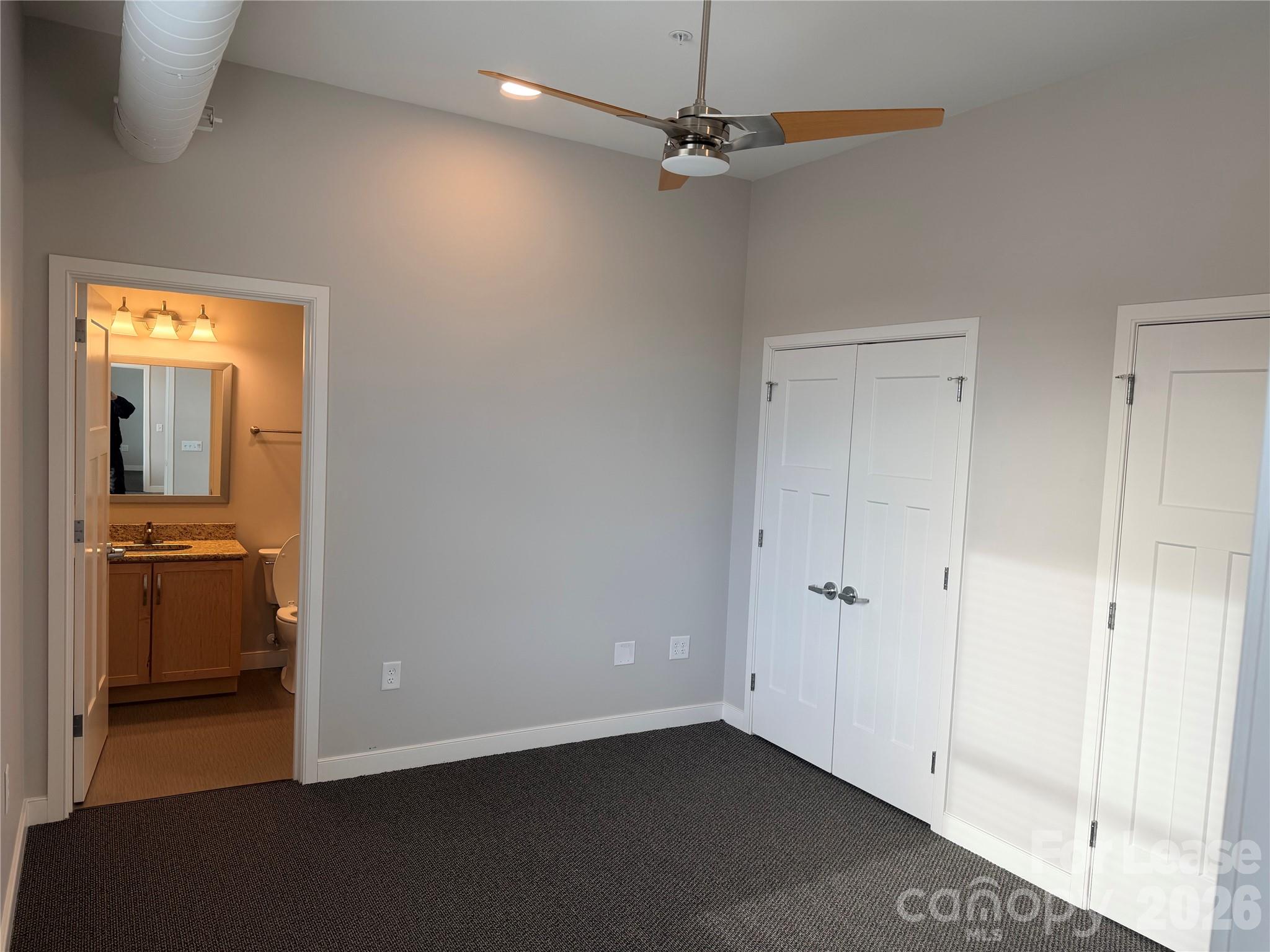 201 East Innes Street, Unit 204 Salisbury, NC 28144 - Photo 19 of 24 an empty room with a mirror and a ceiling fan