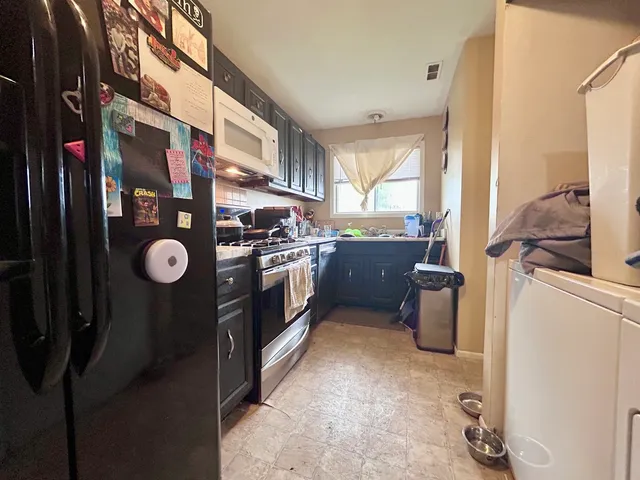 a kitchen with stainless steel appliances granite countertop a sink a stove and a refrigerator