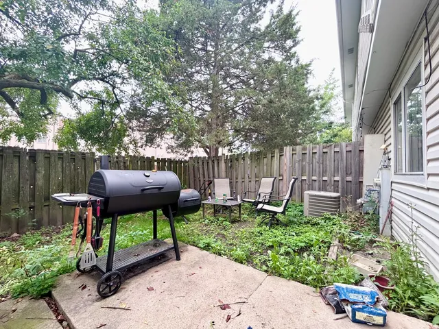 a view of a chair and table in backyard of the house