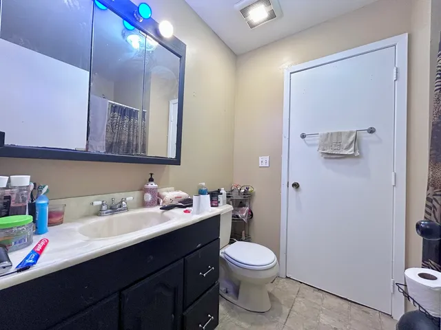 a bathroom with a sink mirror and toilet