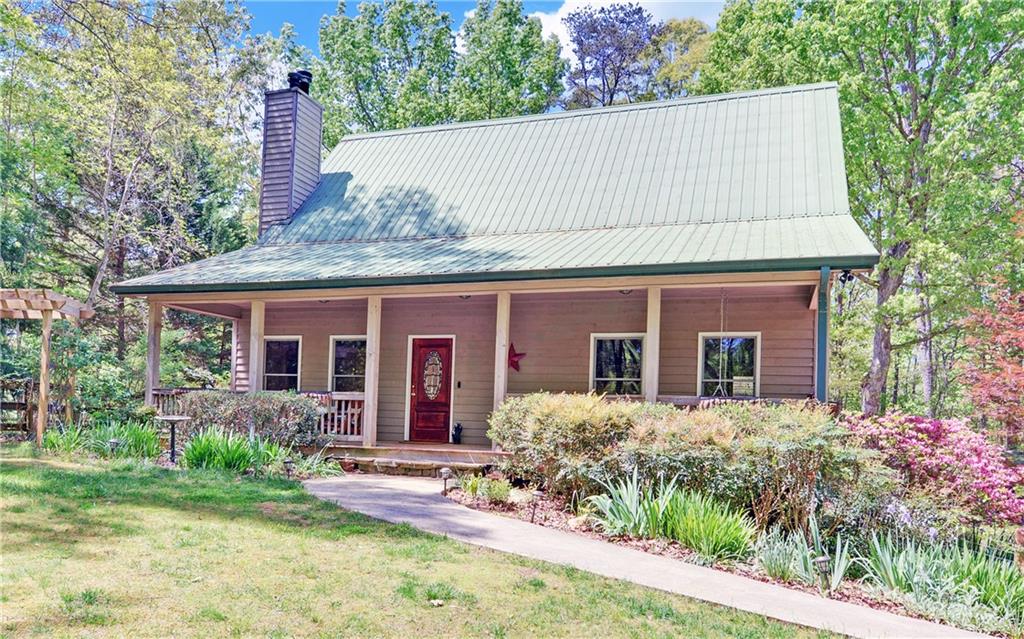 a front view of house with yard and trees around