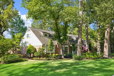 a view of a white house with a big yard and large trees