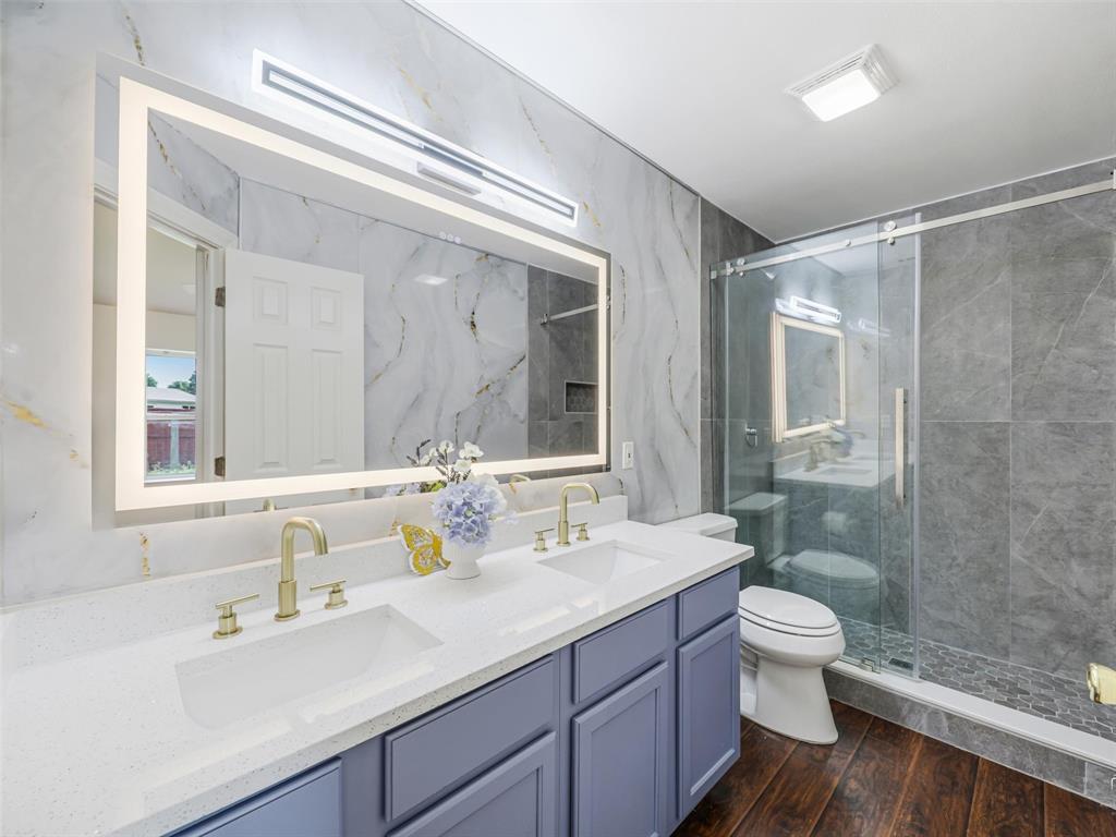 1716 East Parker Road Plano, TX 75074 - Photo 21 of 25 Primary Bathroom featuring a dual-sink vanity with white countertops, gold-finish faucets, and a large illuminated mirror