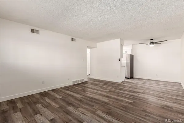 a view of an empty room with wooden floor