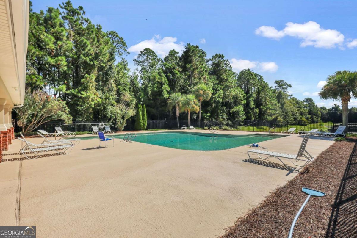 19 Clover Mill Point Brunswick, GA 31525 - Photo 8 of 9 a view of a swimming pool with a yard and palm trees