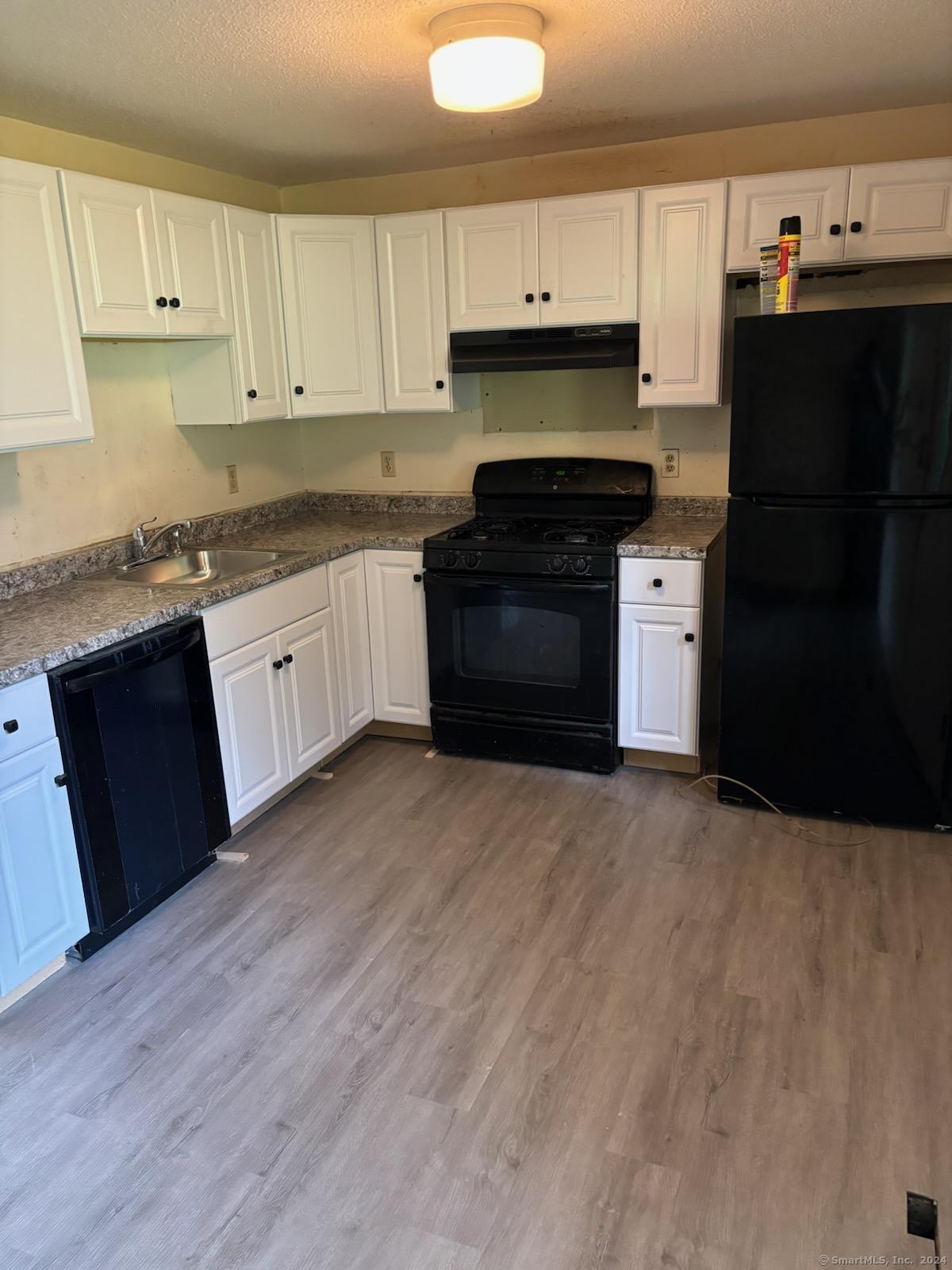 a kitchen with granite countertop a refrigerator stove and sink