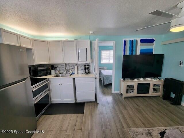 406 Tyler Avenue, Unit 19 Cape Canaveral, FL 32920 - Photo 2 of 13 a kitchen with a refrigerator and a flat screen tv