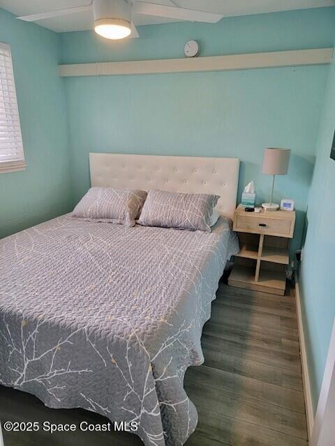 406 Tyler Avenue, Unit 19 Cape Canaveral, FL 32920 - Photo 7 of 13 a bed sitting in a bedroom next to a window with wooden floor