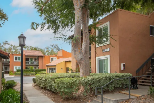 a front view of a house with a yard and fountain in middle of the house