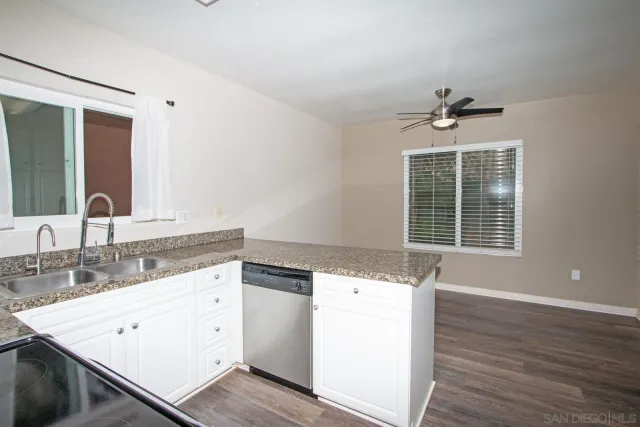 a kitchen with stainless steel appliances kitchen island granite countertop a refrigerator and a sink