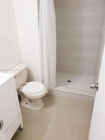 a white toilet sitting next to a shower