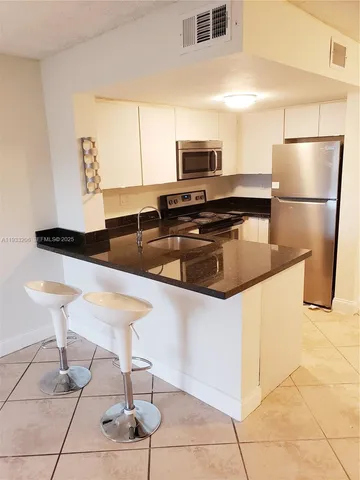 a kitchen with stainless steel appliances granite countertop a sink counter space and cabinets