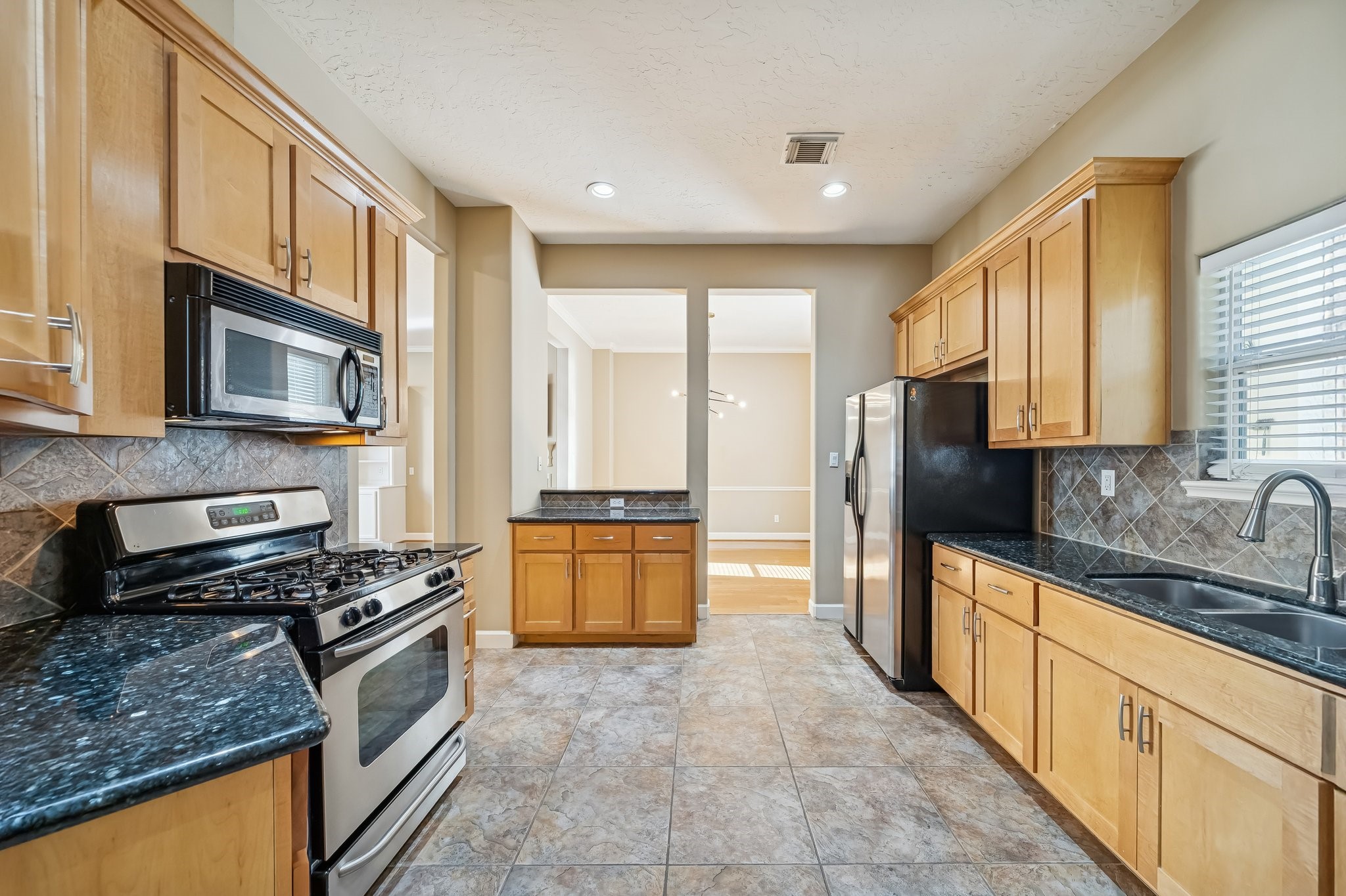1415 Birdsall Street Houston, TX 77007 - Photo 12 of 25 a kitchen with stainless steel appliances granite countertop a stove a sink a refrigerator a microwave oven and cabinets