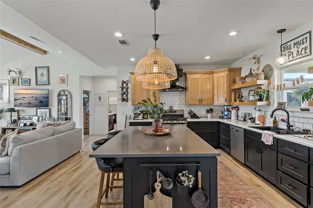 a kitchen with stainless steel appliances a dining table and chairs