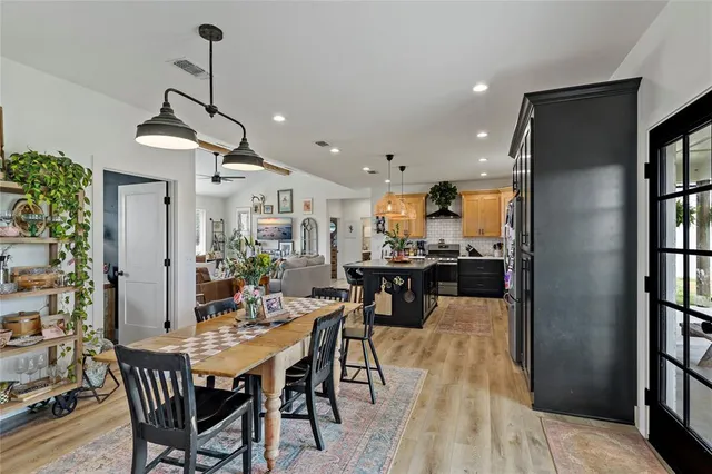 a view of a dining room and livingroom with furniture wooden floor a chandelier