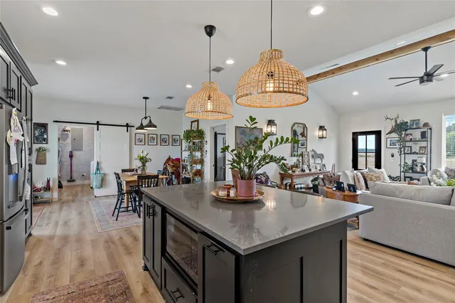 a kitchen with a table chairs and living room view