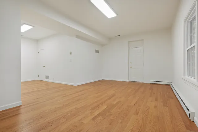 a view of empty room with wooden floor