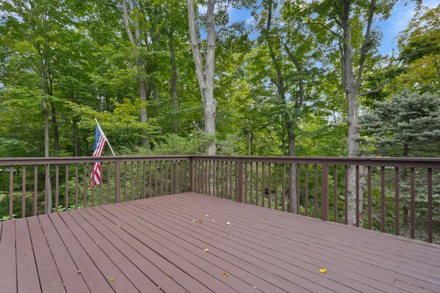 a balcony with wooden floor and trees