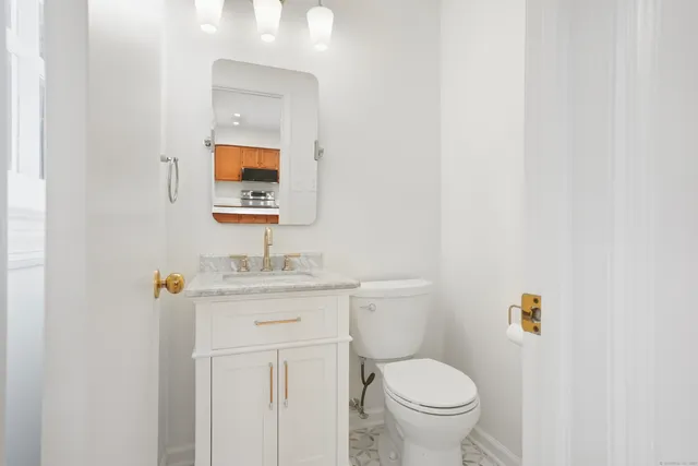 a bathroom with a toilet a sink and mirror