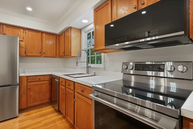 a kitchen with kitchen island granite countertop a sink stainless steel appliances and cabinets