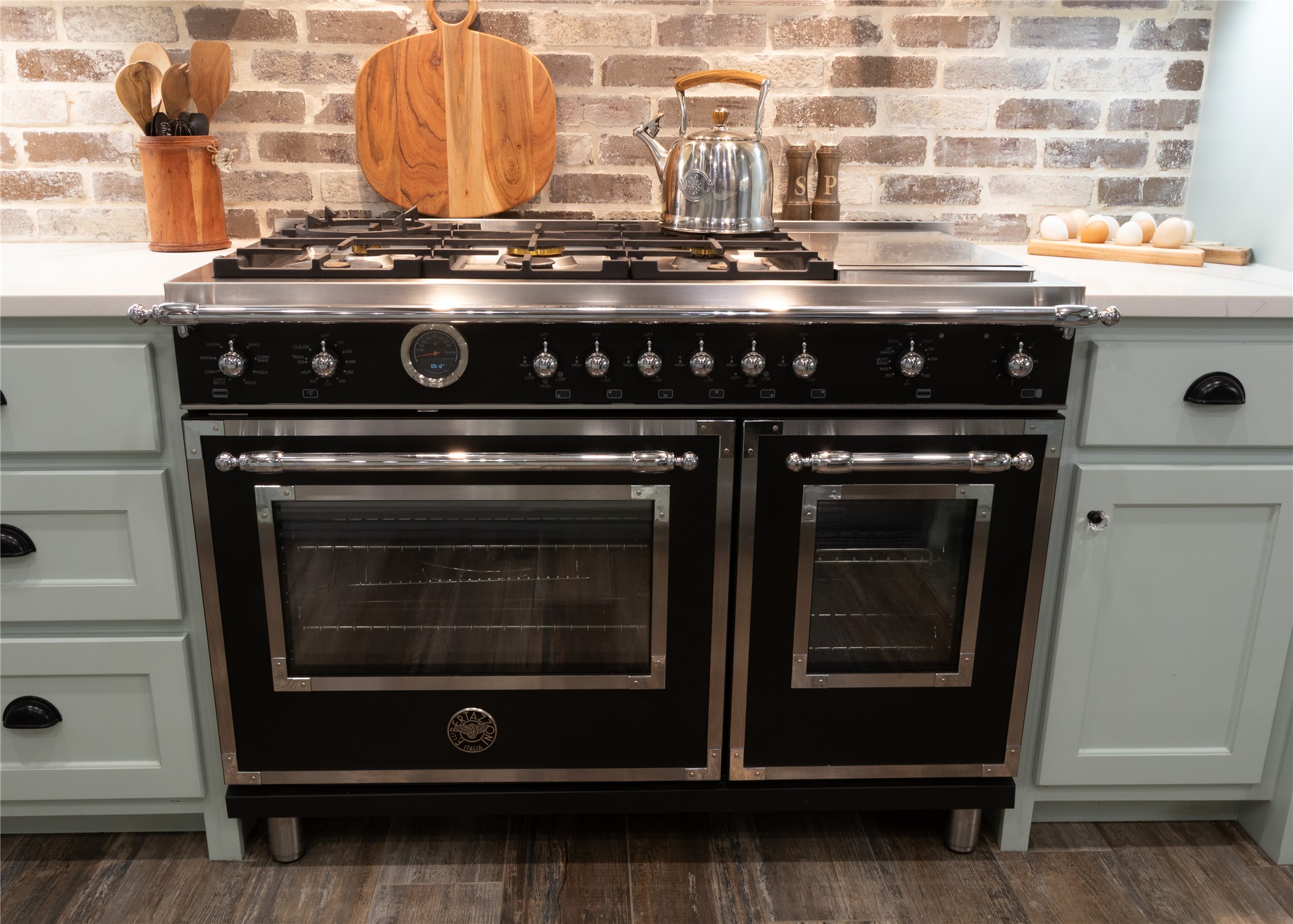272 Slate Rock Road Fredericksburg, TX 78624 - Photo 21 of 32 A striking dual-oven Bertazzoni 'Heritage Series' custom order range commands attention, set against a stylish real brick backsplash and light cabinetry.