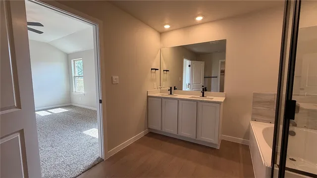 a view of a hallway with bathroom and mirror
