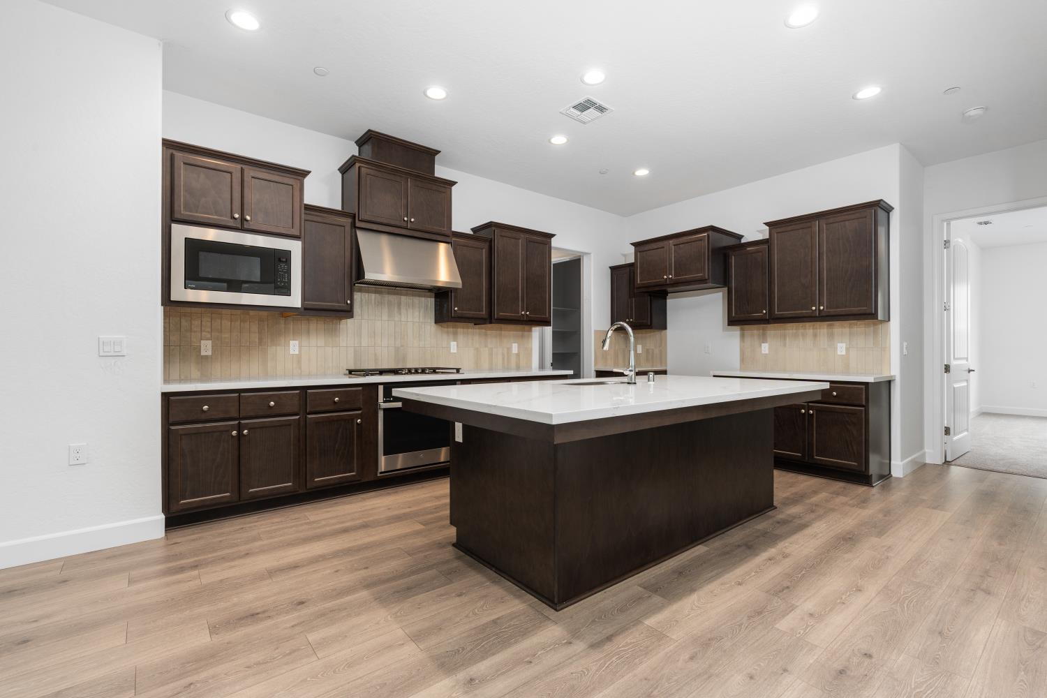 a kitchen with stainless steel appliances kitchen island granite countertop a stove and a sink