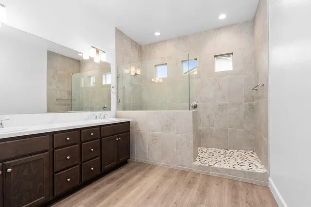 a bathroom with a double vanity sink toilet a shower and a mirror