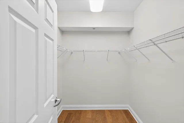 a view of empty room with wooden floor and ceiling fan