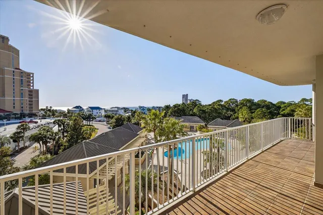 a view of a balcony with wooden floor and outdoor seating