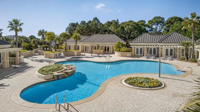 a swimming pool with outdoor seating and barbeque oven
