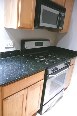a kitchen with granite countertop a sink and a stove