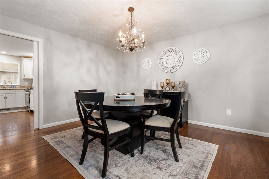 45 Auburn Road Millis, MA 02054 - Photo 13 of 31 a dining room with wooden floor a chandelier a wooden table and chairs