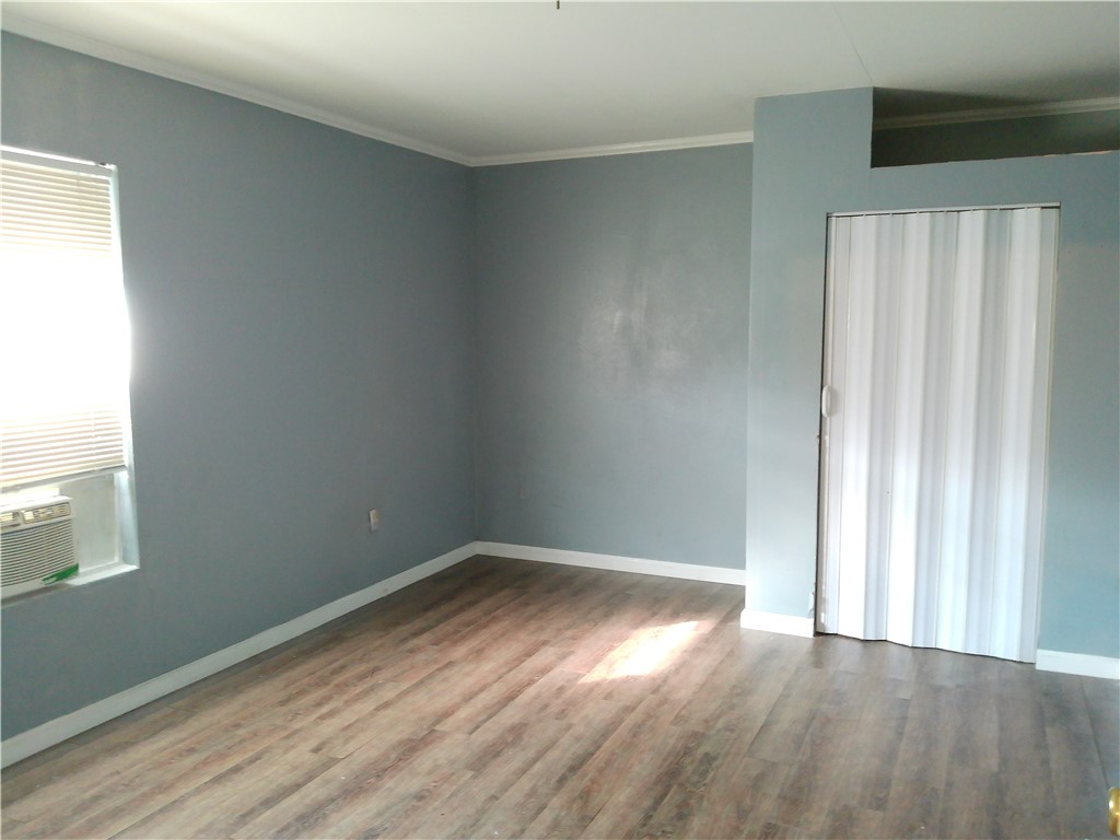 1563 18th Street, Unit B Corpus Christi, TX 78404 - Photo 6 of 7 an empty room with wooden floor and windows