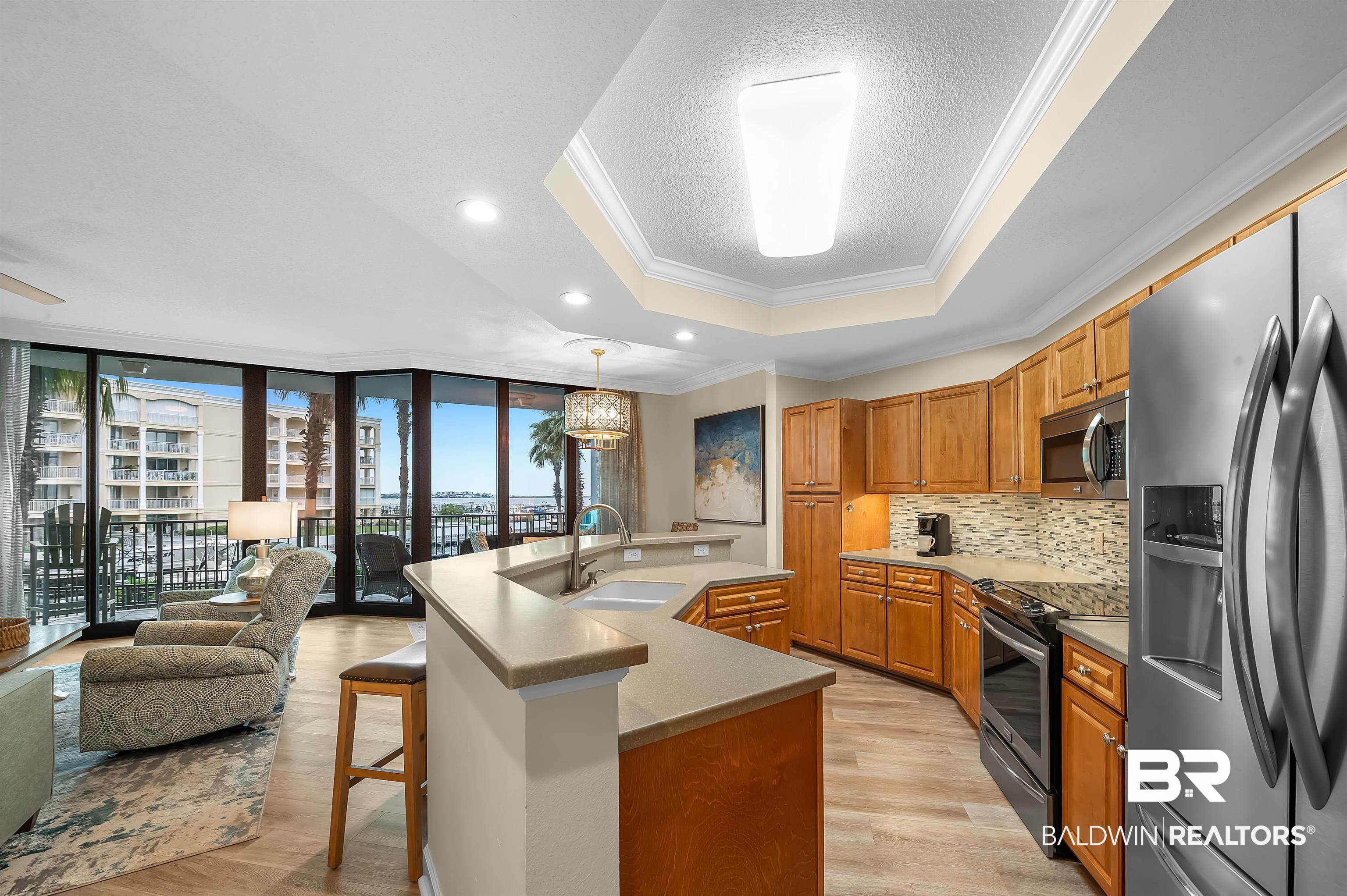 27582 Canal Road, Unit 2104 Orange Beach, AL 36561 - Photo 12 of 35 Kitchen featuring appliances with stainless steel finishes, a healthy amount of sunlight, and a center island with sink