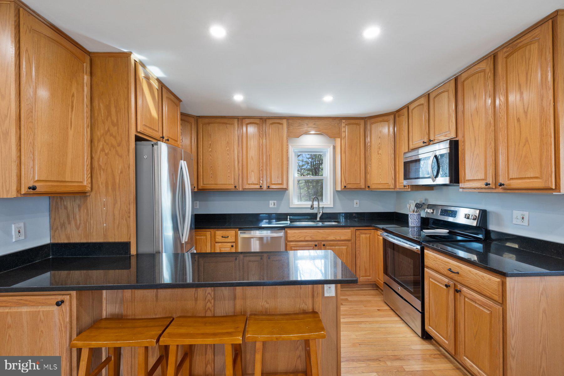 4181 Buffalo Road Mount Airy, MD 21771 - Photo 11 of 38 a kitchen with stainless steel appliances granite countertop wooden cabinets a stove top oven a sink and dishwasher