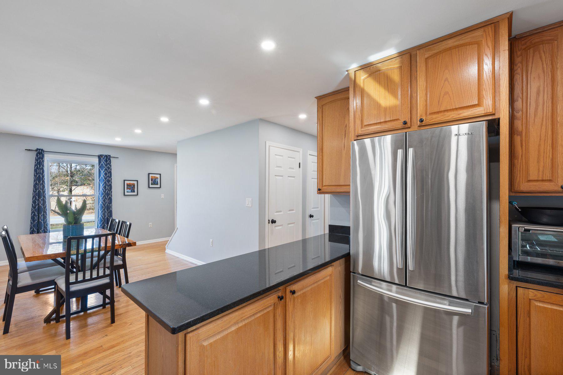 4181 Buffalo Road Mount Airy, MD 21771 - Photo 12 of 38 a kitchen with stainless steel appliances granite countertop a refrigerator a stove and a dining table with wooden floor