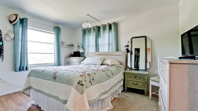 a bedroom with a bed and a flat tv screen on dresser
