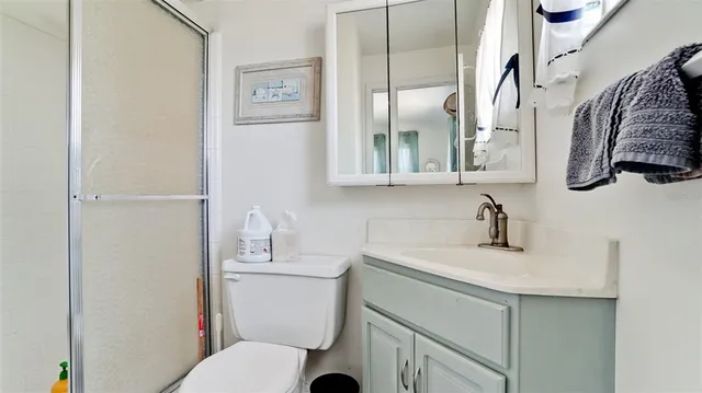 a bathroom with a sink vanity mirror and toilet