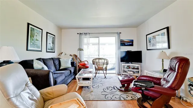 a living room with furniture a flat screen tv and a window