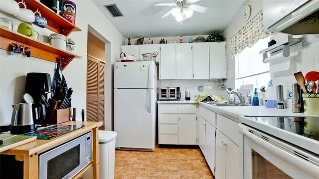 a kitchen with a refrigerator sink and cabinets