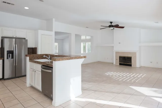 a kitchen with stainless steel appliances granite countertop a stove a refrigerator and a fireplace