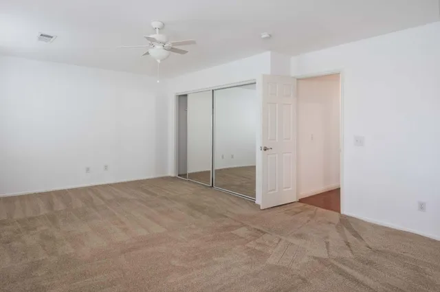 an empty room with fan and a ceiling fan