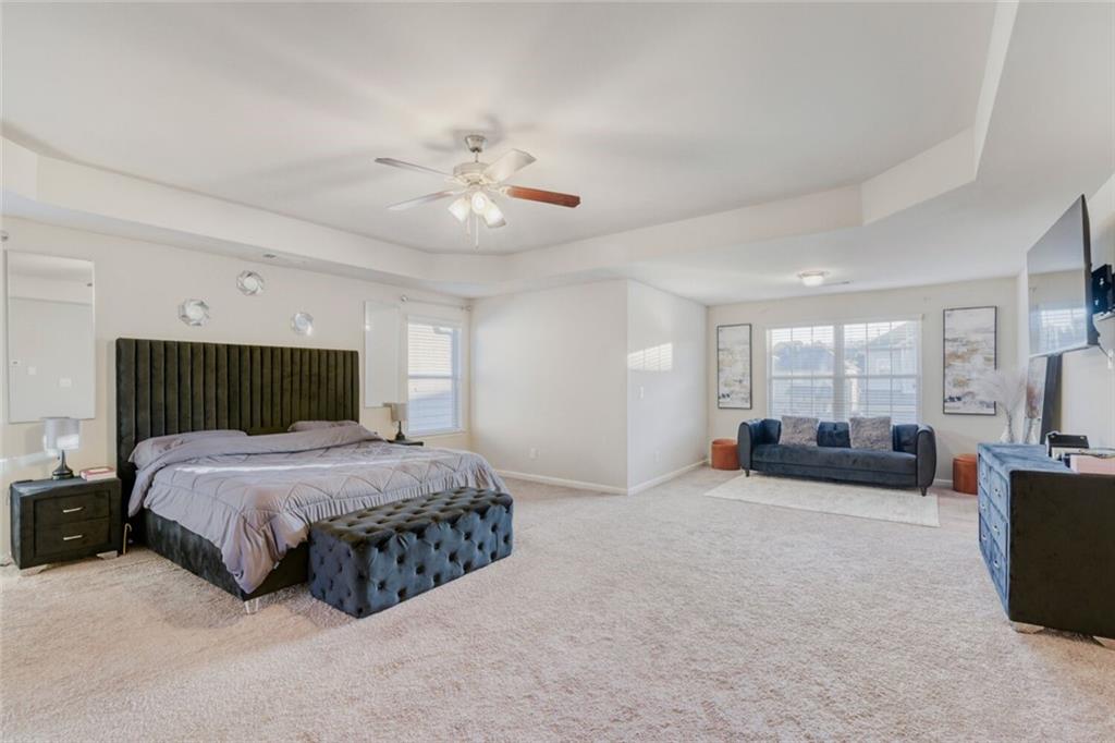 7607 Crawford Court Fairburn, GA 30213 - Photo 15 of 32 a spacious bedroom with a bed and ceiling fan