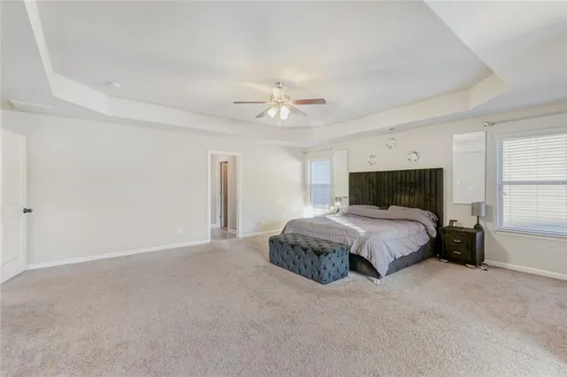 a spacious bedroom with a bed and a ceiling fan