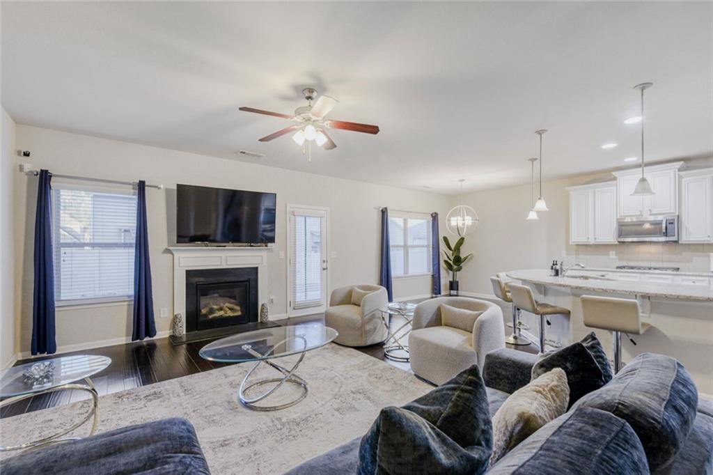 7607 Crawford Court Fairburn, GA 30213 - Photo 3 of 32 a living room with furniture a fireplace and a flat screen tv
